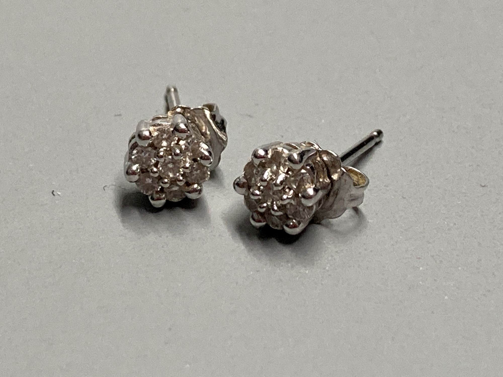 A pair of modern white metal (stamped 750) and small seven stone diamond cluster ear studs, 5mm, gross 1.6 grams.